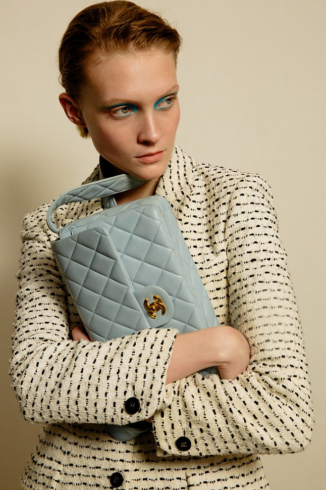 Model wearing Chanel ivory tweed jacket and Chanel baby blue flap bag.