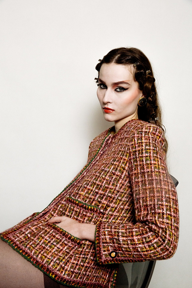 Model wearing Chanel pink tweed jacket and black enamel clip-on earrings.