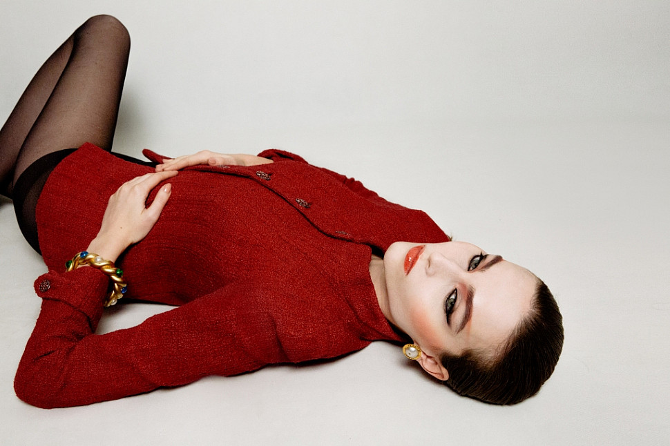 Model wearing Chanel red jacket, Chanel tote silver bag, Chanel gold-plated metal clip-on earrings with pearl and Chanel pearl and gripoix crystal bracelet.